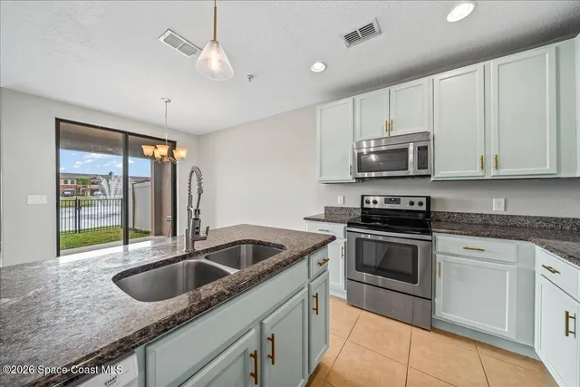 a kitchen with stainless steel appliances granite countertop a sink a stove and microwave