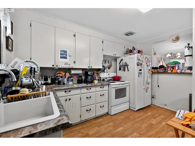 a kitchen with stainless steel appliances kitchen island granite countertop a refrigerator and a stove top oven