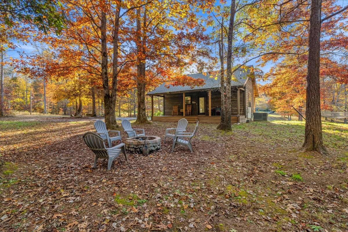 450 Flat Branch Road Tracy City, TN 37387 - Photo 16 of 57 a backyard of a house with barbeque oven table and chairs