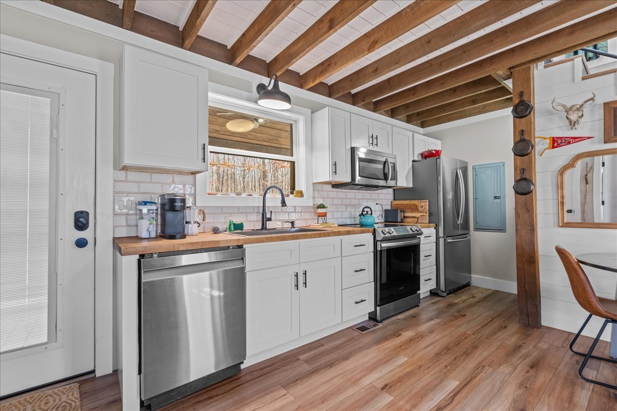 450 Flat Branch Road Tracy City, TN 37387 - Photo 35 of 57 a kitchen with cabinets wooden floor and stainless steel appliances