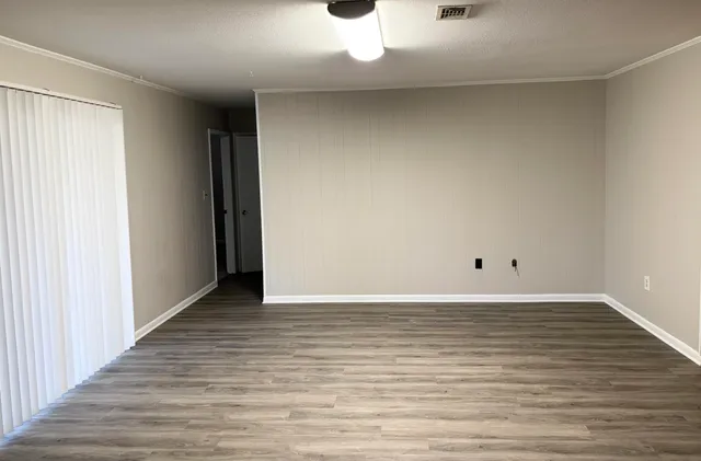 a view of an empty room and wooden floor