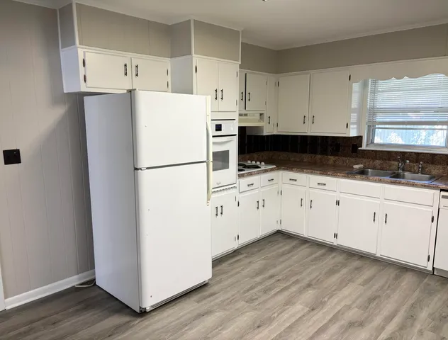a kitchen with white cabinets and white appliances