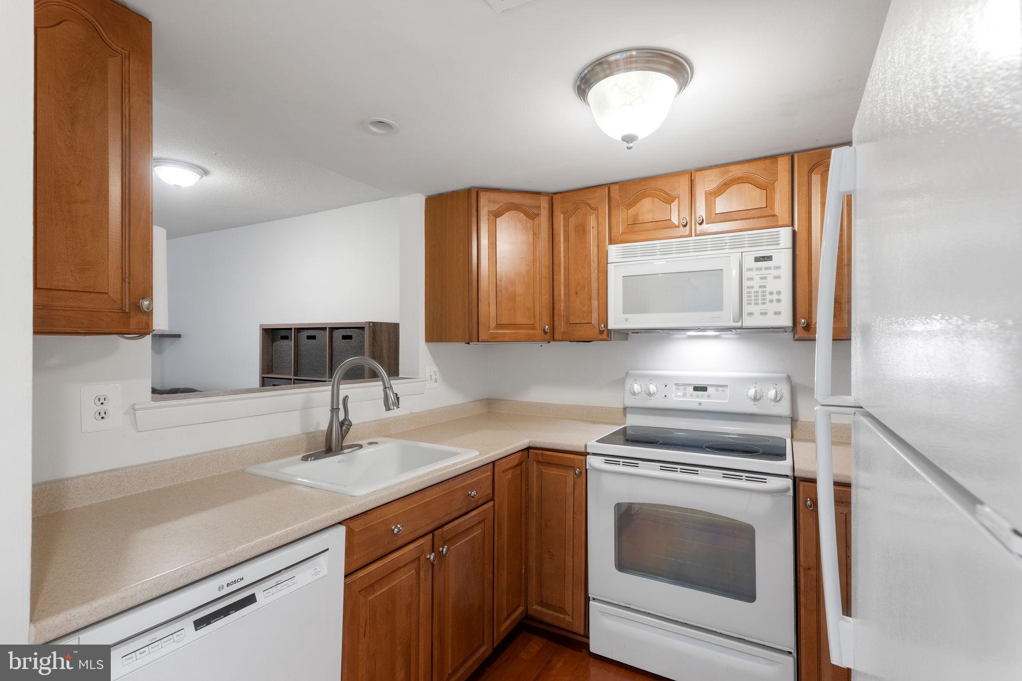 1951 Sagewood Lane, Unit 315 Reston, VA 20191 - Photo 9 of 37 a kitchen with cabinets stainless steel appliances and a sink