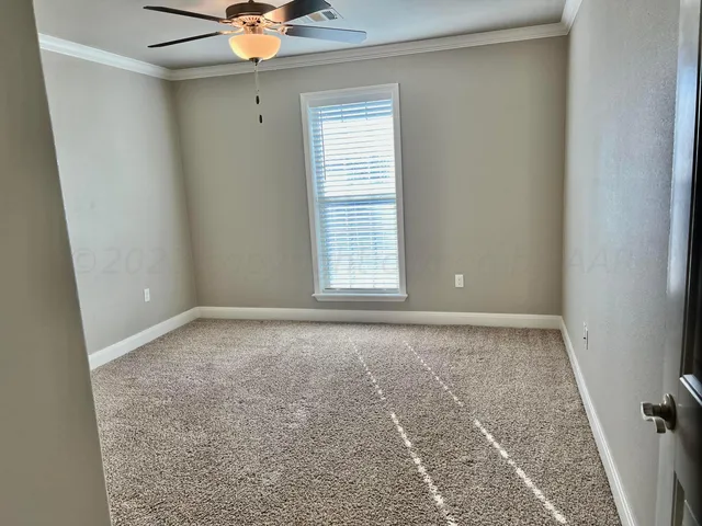 an empty room with a window and a ceiling fan