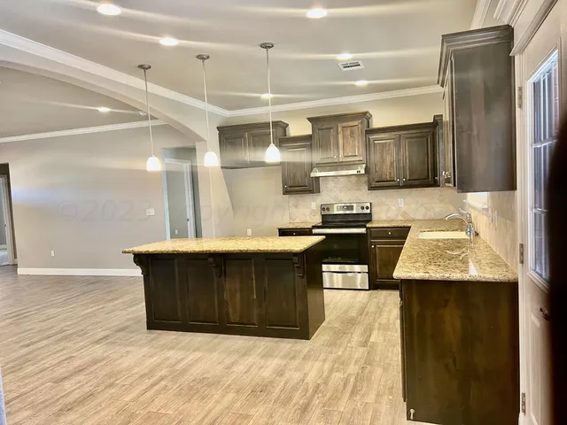 a kitchen with granite countertop a sink and cabinets