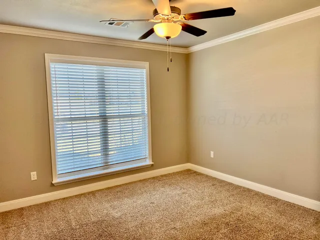 an empty room with a window and chandelier fan