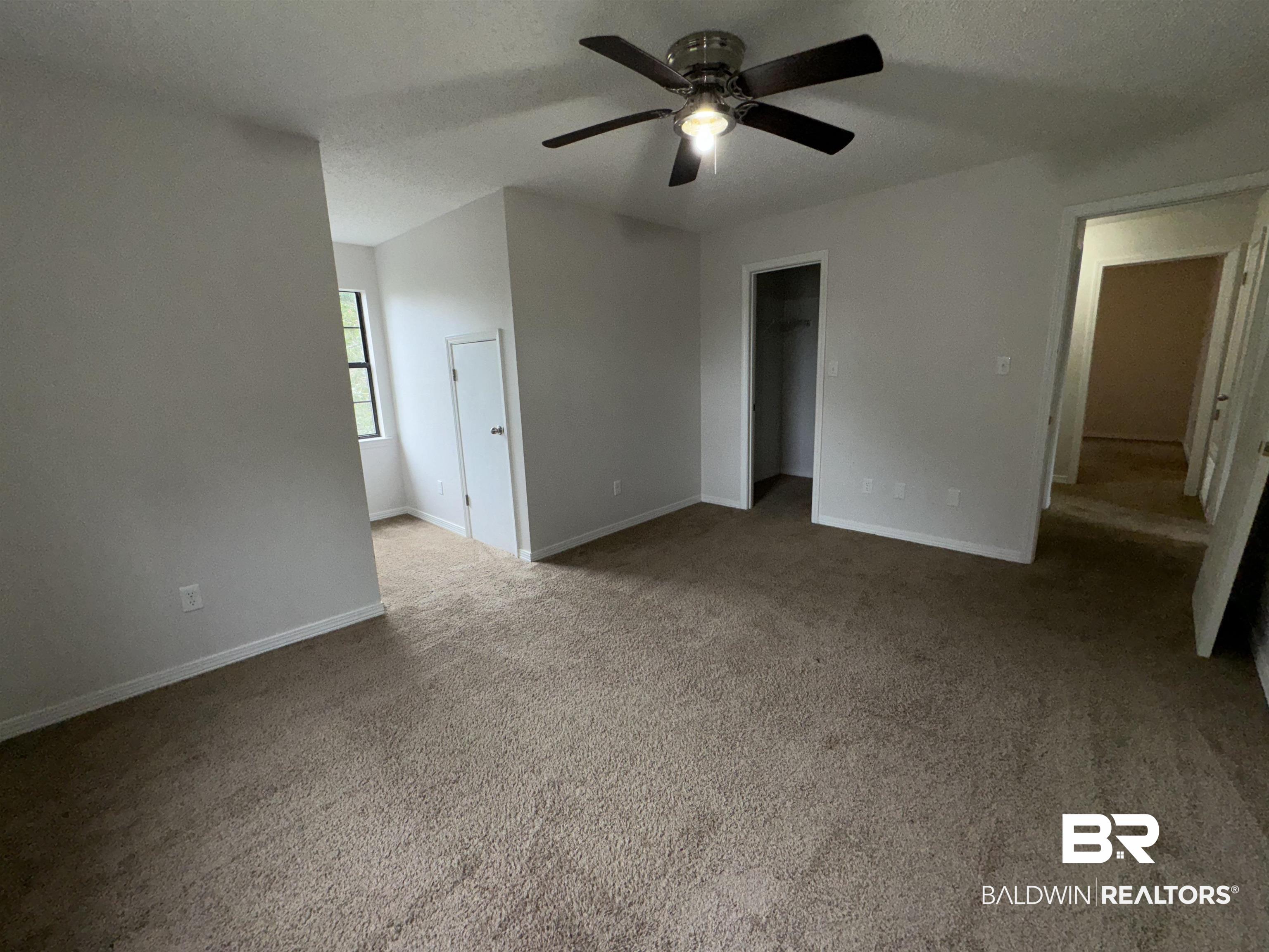 70 Plum Street Uriah, AL 36480 - Photo 24 of 36 Unfurnished bedroom with a closet, a textured ceiling, carpet, a spacious closet, and ceiling fan