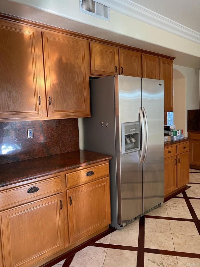 1018 Burga Loop Chula Vista, CA 91910 - Photo 17 of 17 a kitchen with a refrigerator a sink and cabinets