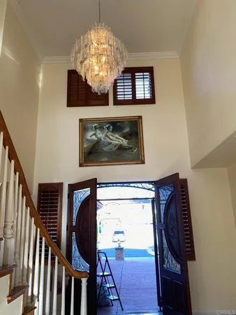 a view of a livingroom with furniture wooden floor chandelier and a chandelier