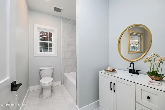 a bathroom with a toilet a sink and a mirror