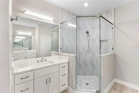 a bathroom with a shower sink and mirror