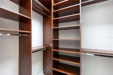 a view of walk in closet with empty racks