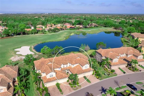 an aerial view of a house with a garden and lake view