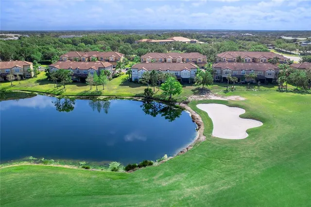 an aerial view of a house with a garden and lake view