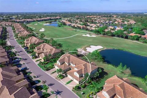 an aerial view of a city with lots of residential buildings and mountain view in back