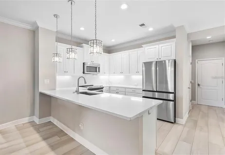 a kitchen with refrigerator cabinets and wooden floor
