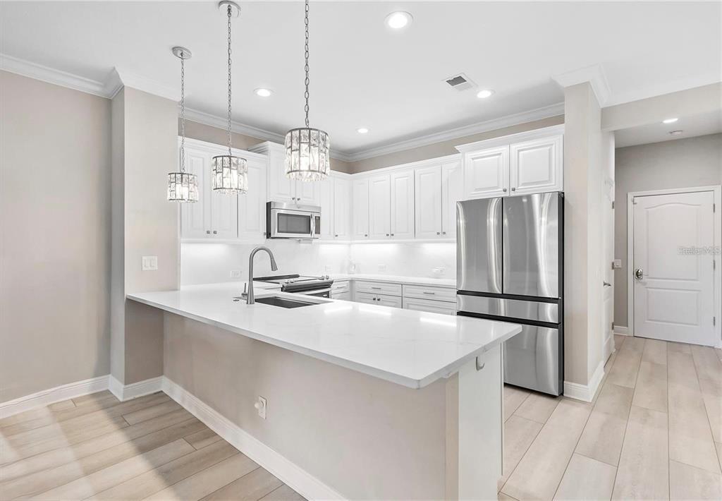 8142 Miramar Way Lakewood Ranch, FL 34202 - Photo 6 of 45 a kitchen with refrigerator cabinets and wooden floor