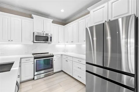 a kitchen with stainless steel appliances a refrigerator sink and microwave