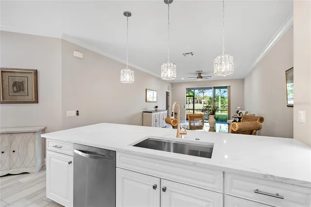 a open kitchen with stainless steel appliances kitchen island a large counter top space a sink wooden floor and windows