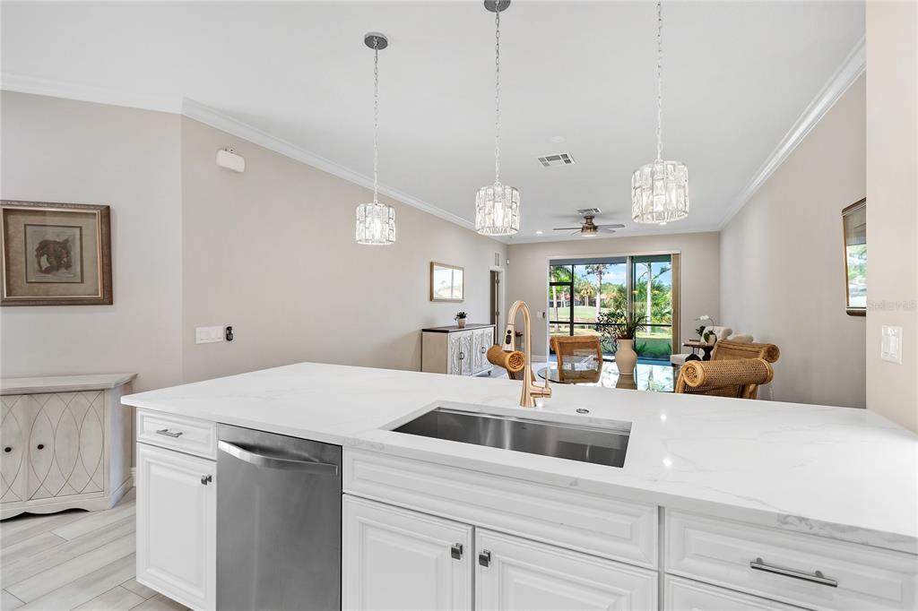 8142 Miramar Way Lakewood Ranch, FL 34202 - Photo 9 of 45 a open kitchen with stainless steel appliances kitchen island a large counter top space a sink wooden floor and windows