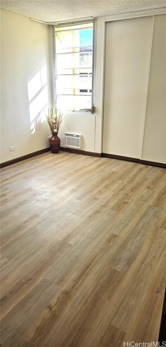 3161 Ala Ilima Street, Unit 309 Honolulu, HI 96818 - Photo 4 of 13 a view of an empty room with wooden floor and a window