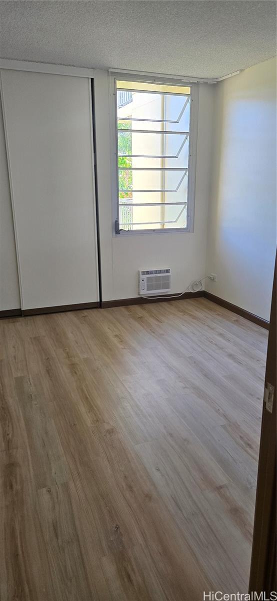 3161 Ala Ilima Street, Unit 309 Honolulu, HI 96818 - Photo 6 of 13 an empty room with wooden floor and windows