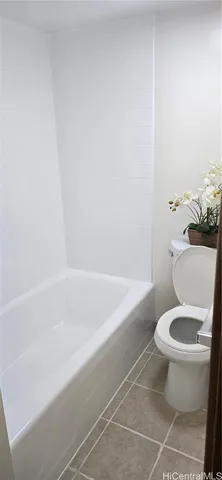 a white toilet sitting next to a bath tub