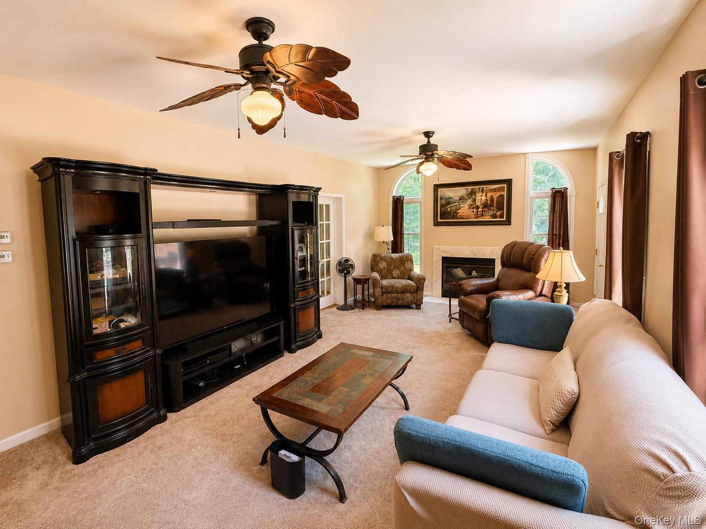 411 Mt Joy Road Middletown, NY 10941 - Photo 40 of 49 Spacious living area featuring neutral carpeting, a fireplace with a stone surround, and multiple arched windows