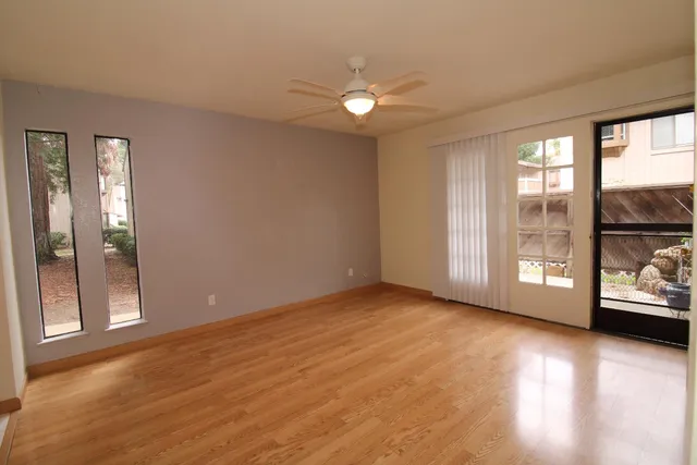 a view of an empty room with glass door and a window