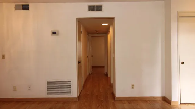 a view of a hallway with wooden floor