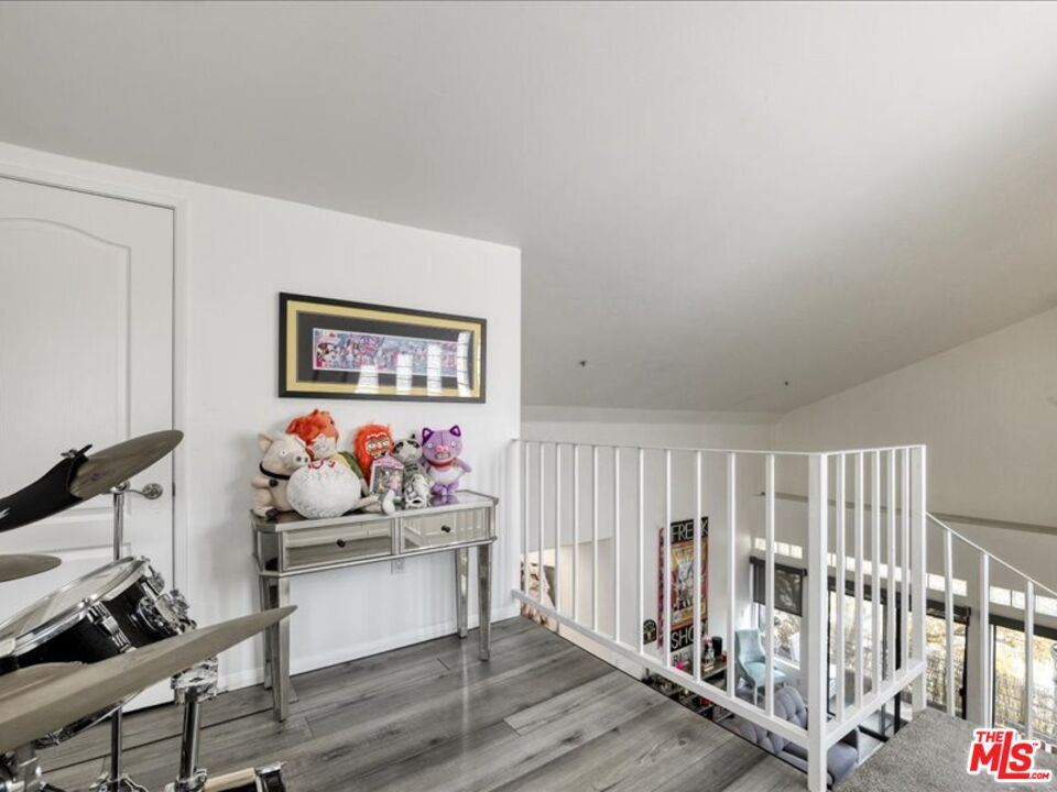 4477 Woodman Avenue, Unit 304 Sherman Oaks, CA 91423 - Photo 15 of 34 a living room with wooden floor and white walls