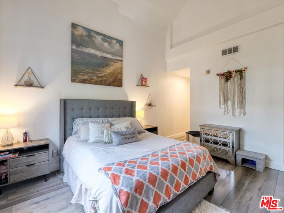 4477 Woodman Avenue, Unit 304 Sherman Oaks, CA 91423 - Photo 17 of 34 a bedroom with a bed and wooden floor