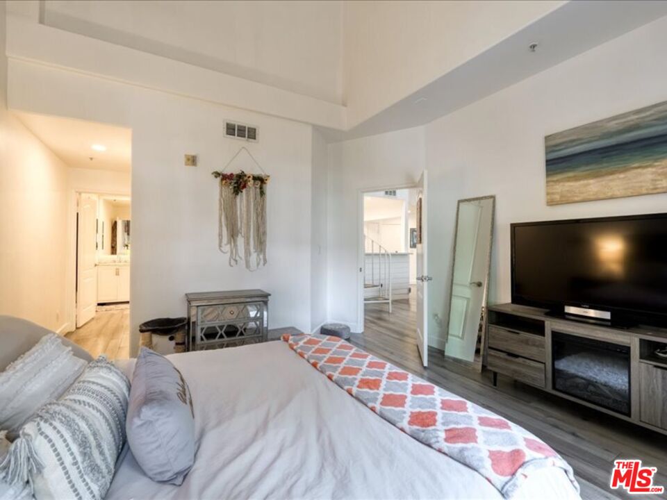4477 Woodman Avenue, Unit 304 Sherman Oaks, CA 91423 - Photo 19 of 34 a bedroom with furniture and a flat screen tv