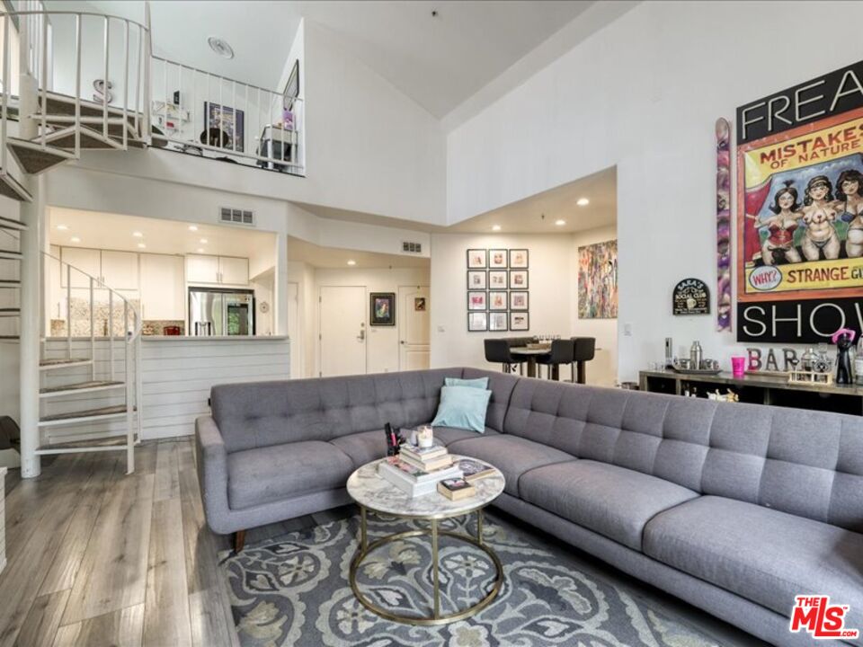 4477 Woodman Avenue, Unit 304 Sherman Oaks, CA 91423 - Photo 2 of 34 a living room with furniture and a dining table with wooden floor