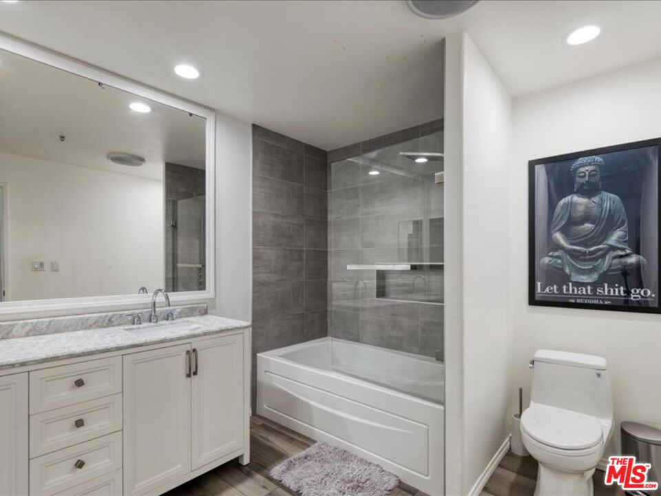 4477 Woodman Avenue, Unit 304 Sherman Oaks, CA 91423 - Photo 22 of 34 a bathroom with a granite countertop sink a toilet and shower