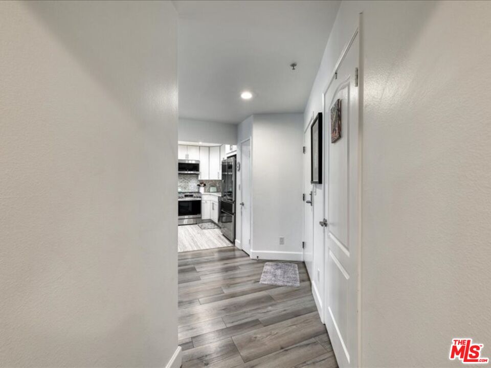 4477 Woodman Avenue, Unit 304 Sherman Oaks, CA 91423 - Photo 25 of 34 a view of a hallway with wooden floor