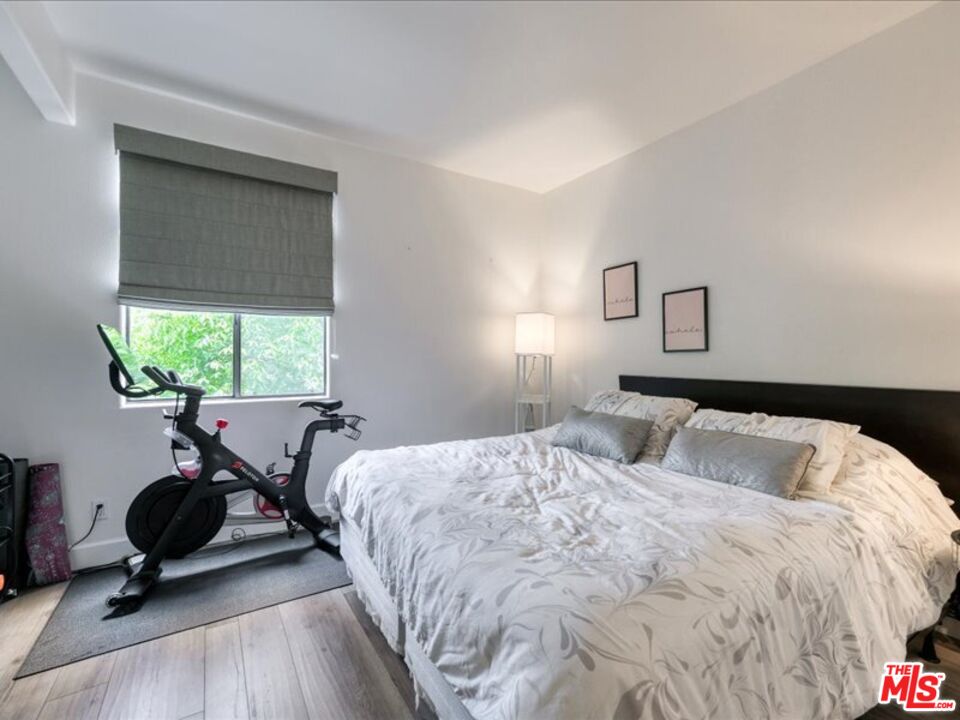 4477 Woodman Avenue, Unit 304 Sherman Oaks, CA 91423 - Photo 27 of 34 a bedroom with a bed and a large window
