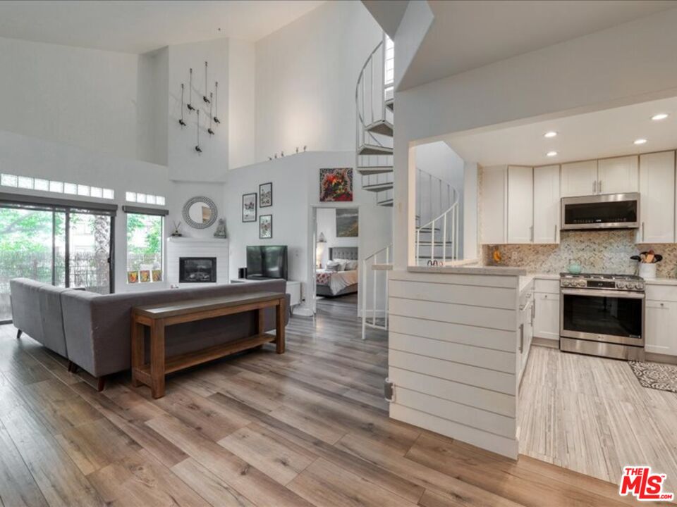 4477 Woodman Avenue, Unit 304 Sherman Oaks, CA 91423 - Photo 4 of 34 a living room with furniture and a kitchen view