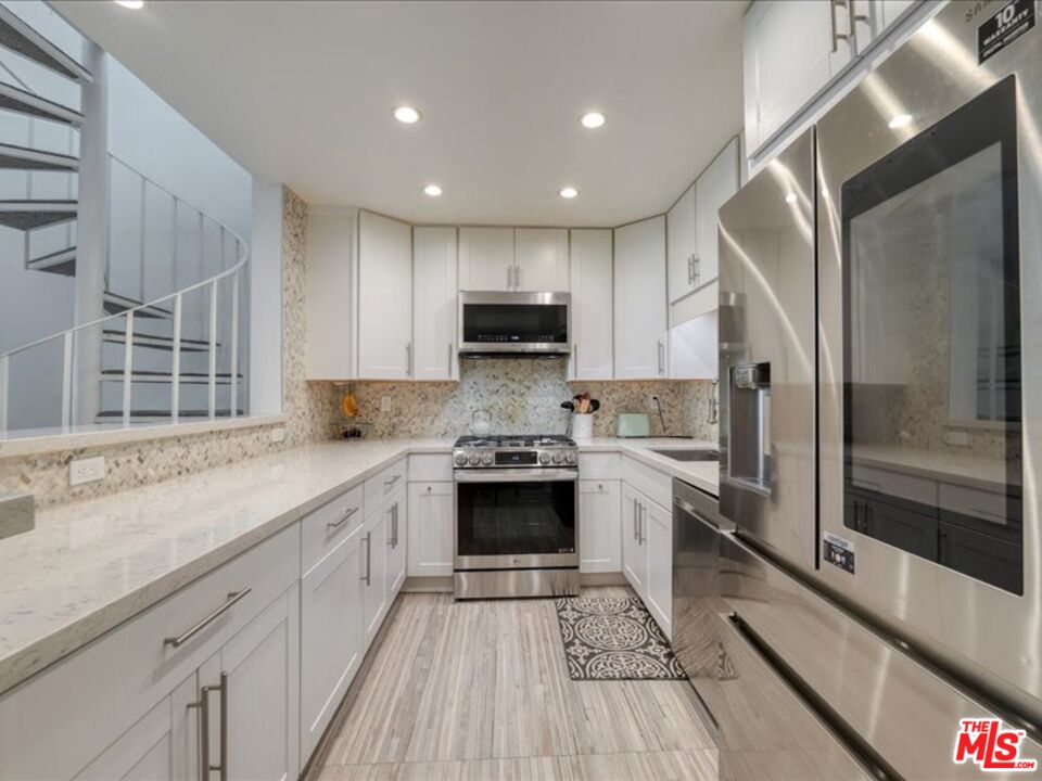 4477 Woodman Avenue, Unit 304 Sherman Oaks, CA 91423 - Photo 5 of 34 a kitchen with a sink stove and refrigerator