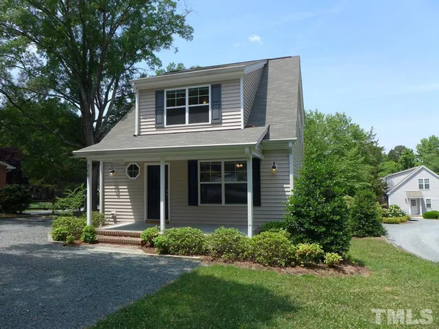a front view of a house with a garden and plants