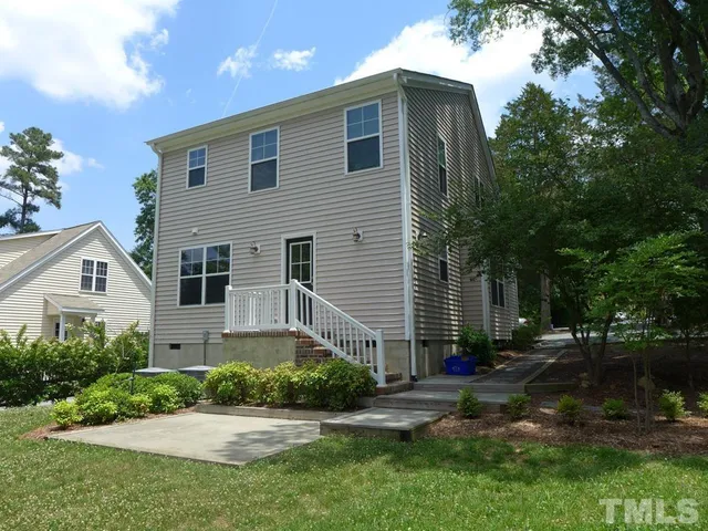 a front view of a house with a yard and potted plants