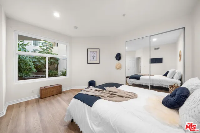 a bedroom with a bed and a large window