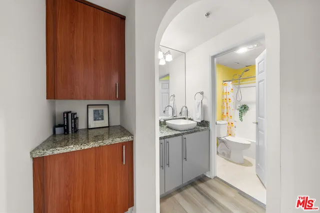 a bathroom with a granite countertop sink and a mirror