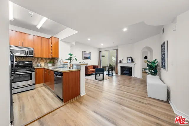 a kitchen with stainless steel appliances granite countertop a stove refrigerator and cabinets