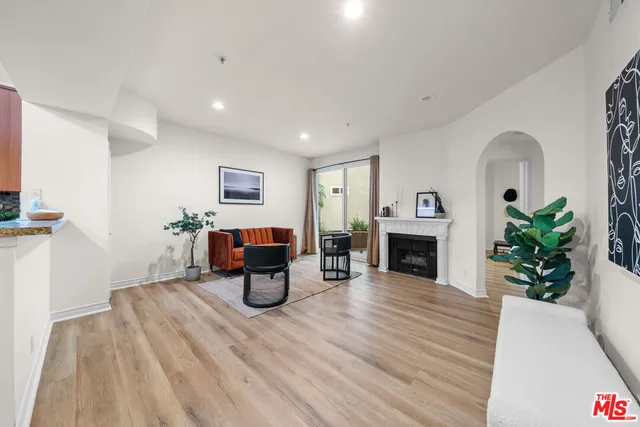a view of a livingroom with a fireplace a chandelier and wooden floor