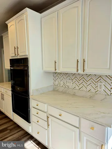 a view of a room with kitchen island stainless steel appliances wooden floor and living room view