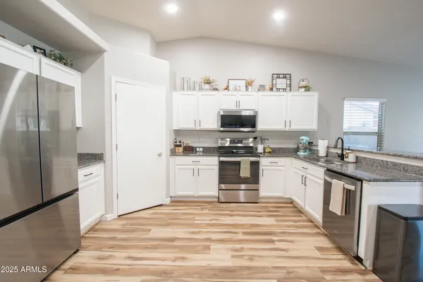 a kitchen with granite countertop a refrigerator and a stove