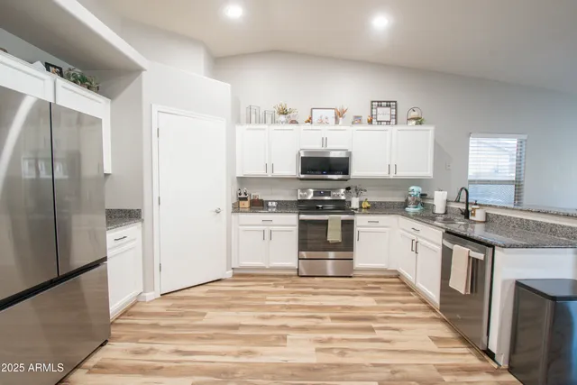 a kitchen with granite countertop a refrigerator and a stove