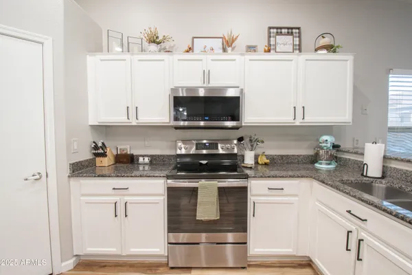 a kitchen with stainless steel appliances granite countertop a stove a sink and a microwave