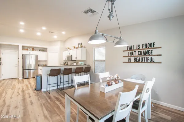 a view of a dining room and livingroom with furniture wooden floor a chandelier
